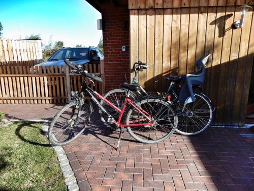 dos bicicletas están estacionadas al lado de una casa en Ferienhaus-Engelking, en Dahme