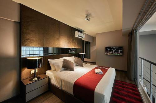 - une chambre avec un grand lit et une couverture rouge dans l'établissement Maritime Luxury Suites, à George Town