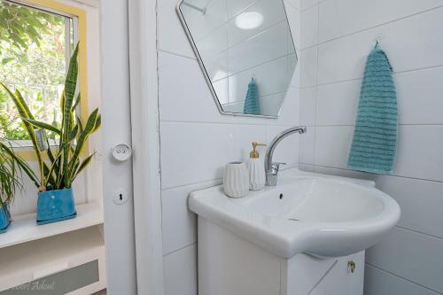 a white bathroom with a sink and a mirror at בית גלילי מול היער in ‘Ein Ya‘aqov