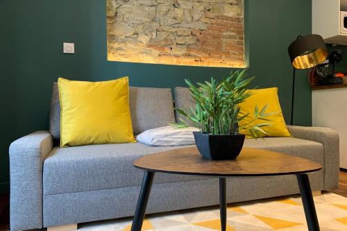un canapé avec des oreillers jaunes et une table dans l'établissement #CD L' Ainé Jean Jaurès Tramway A B and E T3 équipé, à Grenoble