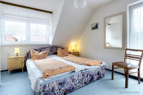 a small bedroom with a bed and a chair at Bossow, Regina in Zingst