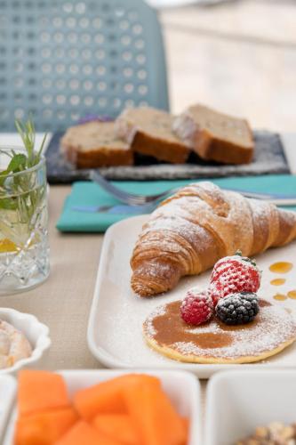 a plate of bread and berries on a table at Hotel Vita Serena in Arma di Taggia