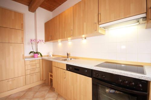 a kitchen with wooden cabinets and a sink at Bellevue rechts in Schashagen