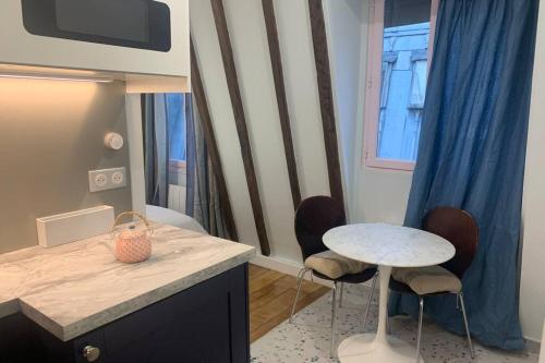 une cuisine avec un comptoir, une table et des chaises dans l'établissement PARIS 4 LE MARAIS Hôtel de Ville LIFT, à Paris