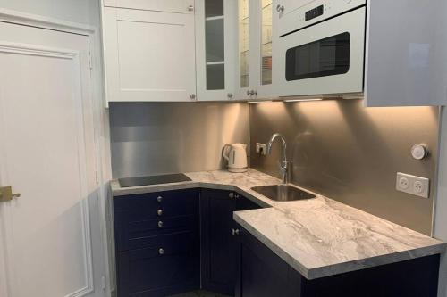 une cuisine avec un évier et un micro-ondes dans l'établissement PARIS 4 LE MARAIS Hôtel de Ville LIFT, à Paris