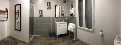 a bathroom with a sink and a mirror at Logis Hôtel Restaurant Métropole in Mirande