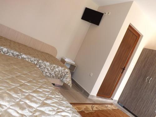 a bedroom with a bed and a wooden door at Hotel Fantasy in Lyubimets