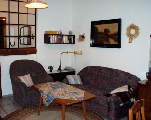 a living room with a couch and a table at FeWo 2 - Haus Lorenzen in Hörsten