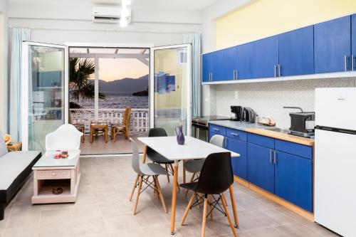 a kitchen with blue cabinets and a table and chairs at Nautilus in Matala