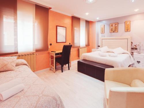 a hotel room with two beds and a desk at Hotel Los Toreros in Tordesillas