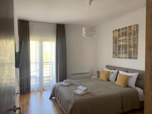 ズラティボールにあるApartman ČAROBNI BREGのタオルが敷かれた大きなベッドのある寝室