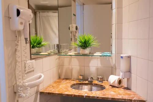 y baño con lavabo y espejo. en Hotel Dion en Mar del Plata