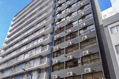 un alto condominio con finestre e condizionatori d'aria di Hotel Dion a Mar del Plata