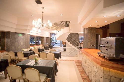 Un comedor con mesas y sillas y una escalera. en Hotel Dion, en Mar del Plata
