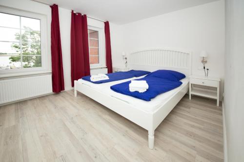 Rabenkirchen-FaulückにあるSchleiblick App 12のベッドルーム1室(青いシーツと窓付)