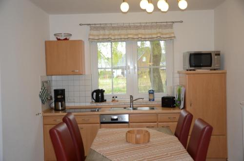 a kitchen with a table and a sink and a window at Am Deich 15 in Zingst