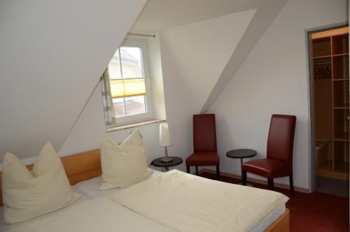 ツィングストにあるAm Deich 15のベッドルーム1室(ベッド1台、赤い椅子2脚付)
