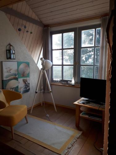 Habitación con escritorio, ordenador y ventanas. en Lodge 31, en Neue Tiefe Fehmarn