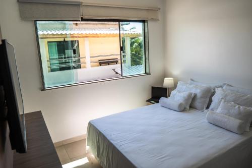 a bedroom with a large bed with a window at Pousada Boipeba Beach in Ilha de Boipeba