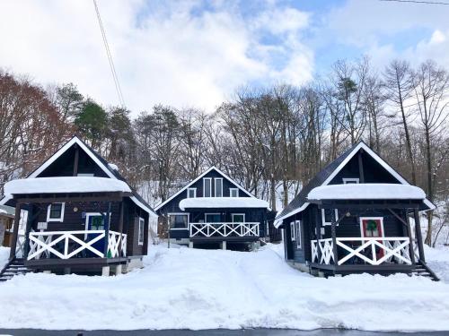 three blue cabins with snow on the roofs at Okayama Hiruzen Villas Peter Pan in Makago