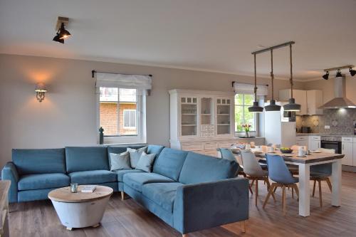 a living room with a blue couch and a table at Reethaus 1A in Staberdorf