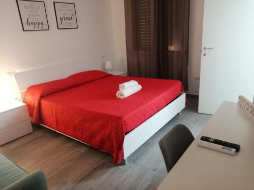 a bedroom with a red bed with a red blanket at La cittadella rooms in Monserrato