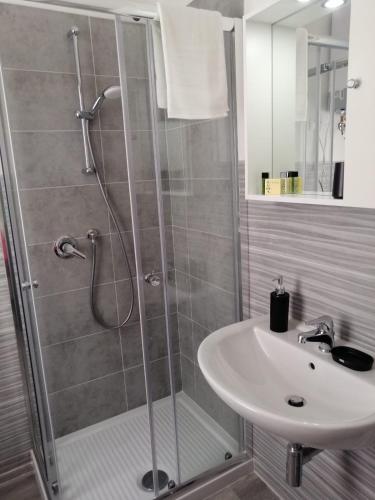 a bathroom with a shower and a sink at La cittadella rooms in Monserrato