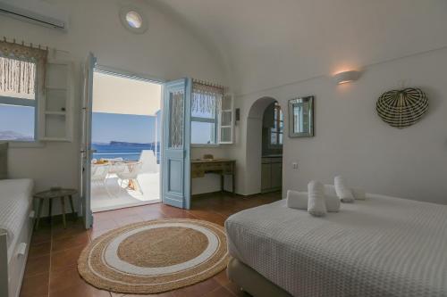 a bedroom with a bed and a view of the ocean at Petinos traditional house in Therasia