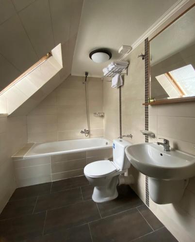 a bathroom with a sink and a toilet and a tub at Hotel Fluss Oase - Feldschlößchen in Weißenfels