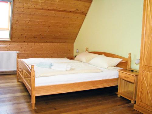 a bedroom with a wooden bed with white sheets at Ihrgistern, FW 3 in Zingst