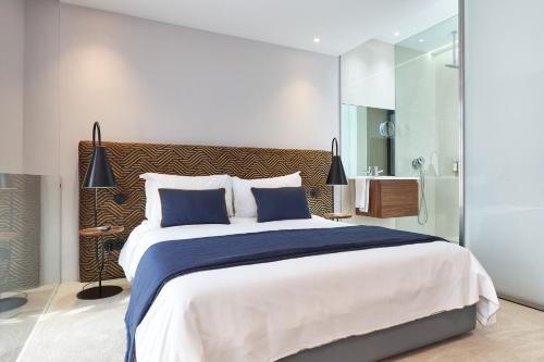a bedroom with a large bed and a bathroom at Rio da Vila in Porto