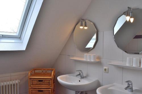 a bathroom with two sinks and two mirrors at Am Hinrichsberg oben in Staberdorf
