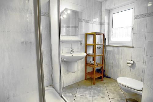 a white bathroom with a sink and a toilet at Hirschberger, Christian, FW 2 in Zingst