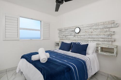 a bedroom with a bed with blue and white sheets at Chakas Cove in Ballito
