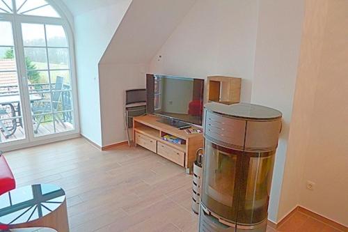 uma sala de estar com uma televisão de ecrã plano e uma mesa em Strandresidenz Deichgraf 8 em Zingst