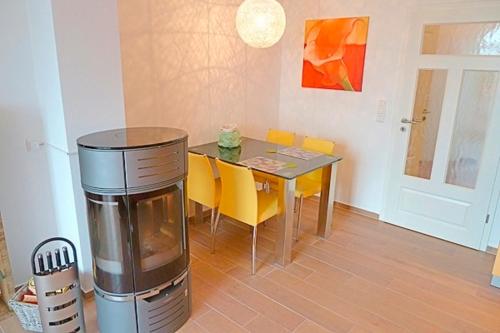 uma sala de jantar com uma mesa e cadeiras amarelas em Strandresidenz Deichgraf 8 em Zingst