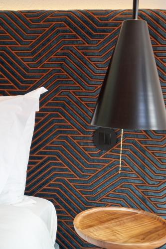 a black lamp hanging on a wall with a table at Rio da Vila in Porto