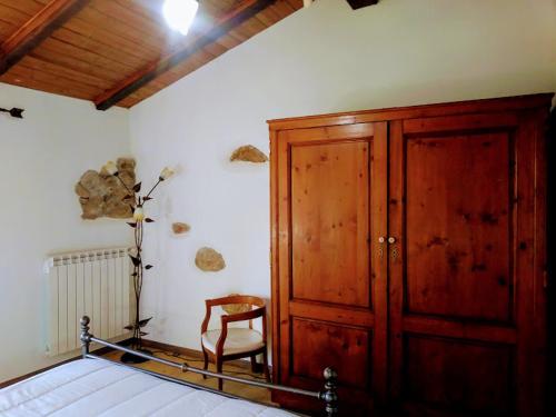 1 dormitorio con armario de madera y silla en Il Pettirosso, en Castellamonte