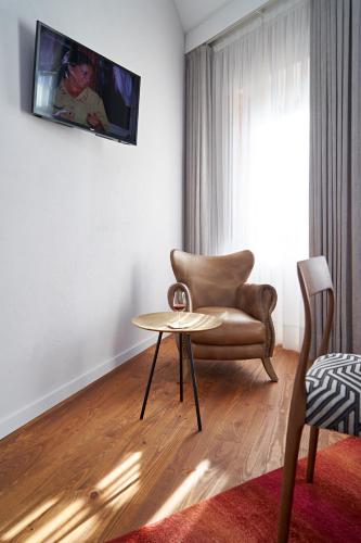 a living room with a chair and a table at Rio da Vila in Porto
