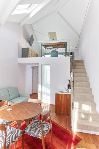 a living room with a table and a staircase at Rio da Vila in Porto