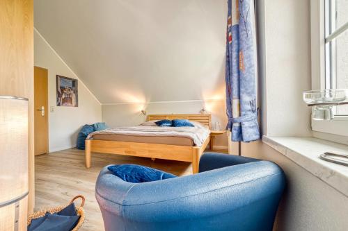 a bedroom with a bed and a blue chair at Alte Reihe 10 Whg 7 in Zingst