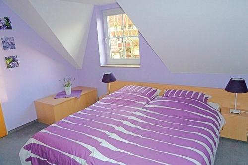 a bedroom with a purple bed and a window at Am Deich 44 in Zingst