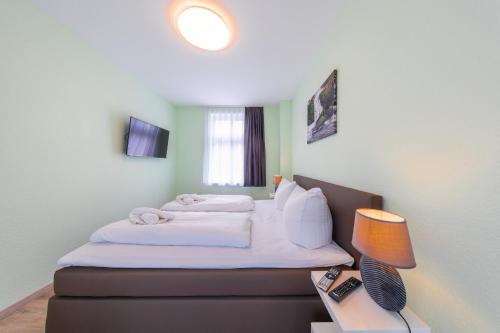 een slaapkamer met een bed en een tafel met een lamp bij Remise 2 - a44208 in Wernigerode