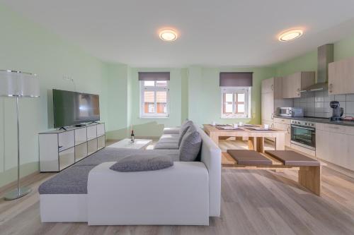een woonkamer met een witte bank en een keuken bij Remise 2 - a44208 in Wernigerode