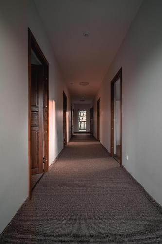 an empty hallway of an empty building with doors at Vėjo Malūnų sodyba - vila in Paserninkai