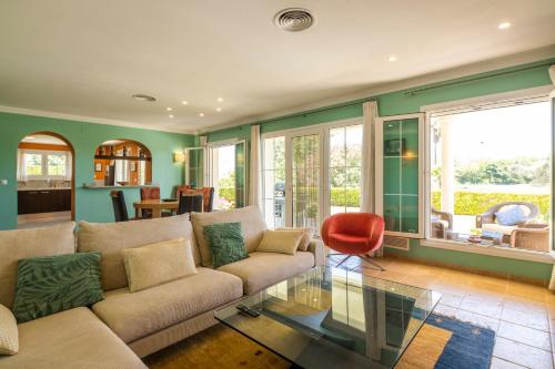 a living room with a couch and a red chair at Villa Lujo Olivanova Golf MET in Oliva