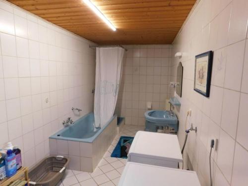 a bathroom with a blue tub and a toilet at FeWo Inge in Landscheid