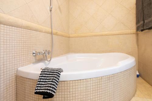 a bathroom with a bath tub with a black and white towel at Villa Lujo Olivanova Golf MET in Oliva