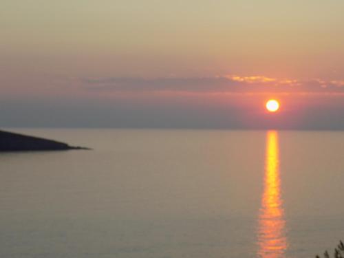 a sunset over the water with the sun in the sky at MOUSELIS APARTMENTS in Kalymnos
