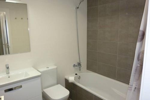 a bathroom with a sink and a toilet and a bath tub at Brisa de Mar en Oliva Nova, junto a MET y golf in Oliva
